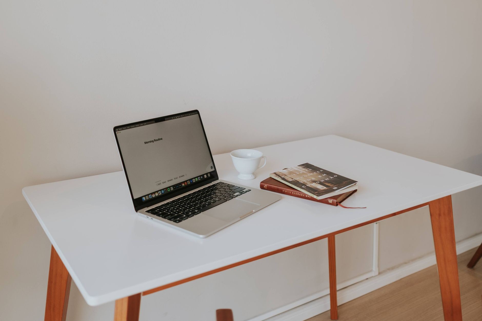 MacBook ouvert sur un bureau épuré, avec une tasse de café, dans un environnement de travail calme