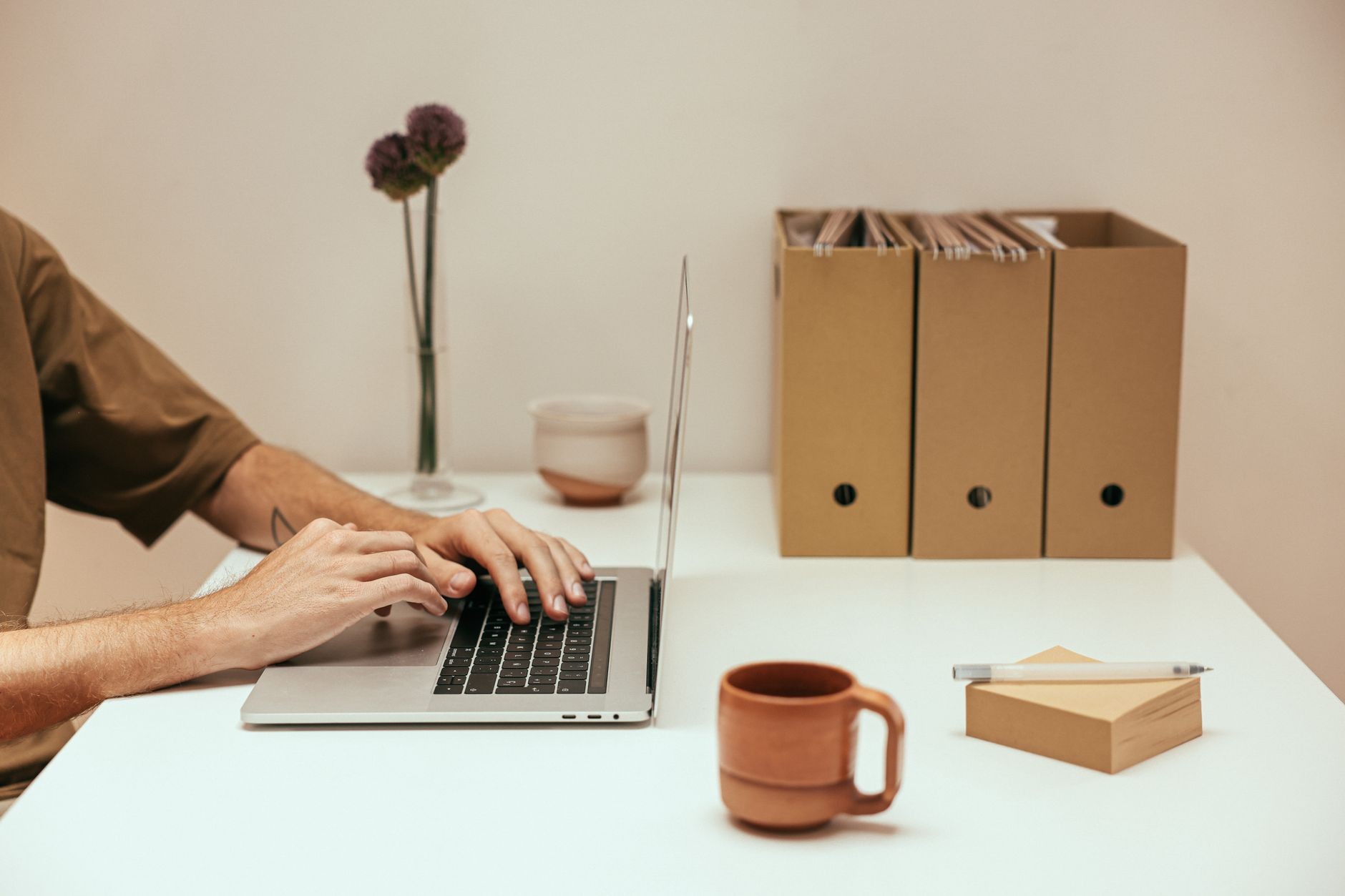 Personne tapant sur un ordinateur portable dans un espace de travail minimaliste
